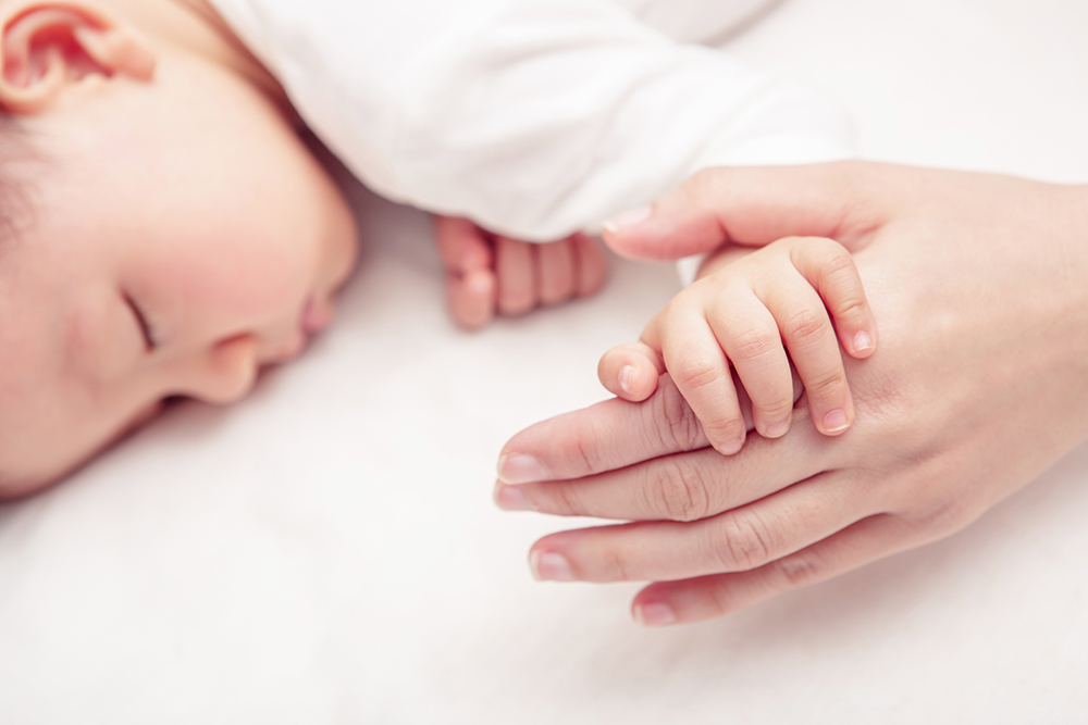 Hand,Of,Sleeping,Baby,In,The,Hand,Of,Mother,Close